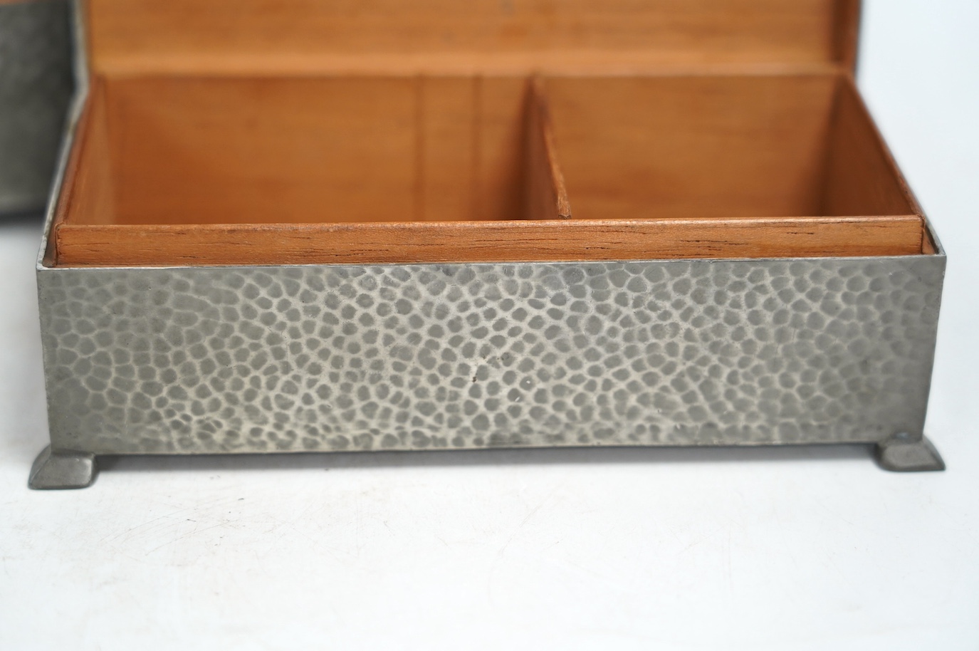 Two pewter cigarette boxes including a Liberty Tudric hammered form, largest 17.5cm wide. Condition - good